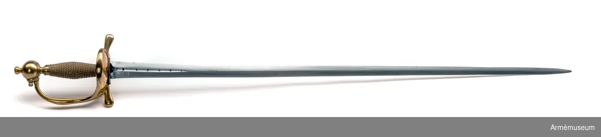 Klingan är tveeggad. Upptill på bägge sidor har den en omkring 140 mm lång blodrand. På yttersidan sitter dessutom en P-stämpel. Vid varje blodrands nedre ände finns ett delvis bortslipat, av prickar bestående ornament. Klingan är starkt avslipad, så att åsarna nedanför blodrandens slut nära nog förvandlats till ryggar. Fästet är av mässing och av drabanttyp. Knappen har formen av ett hoptryckt klot samt har rygg på fram- och baksidan. Knappens diameter är i sidled 37,5 mm, men över ryggarna 40,5 mm. Höjden är 33 mm. Upptill har knappen en stor nitknapp, som är instrypt. Nitknappens höjd är 16 mm, och diametern är 16 mm. Den har en spetsoval fot, som är 22 mm lång och 17 mm bred. Halsen är instrypt och 11 mm hög. Gränsen mellan nitknappen och knappen samt mellan knappen och halsen markeras genom en rand eller avsats. En dylik går även kring halsens nedre del. Knappen är rätt illa gjuten. Kaveln är spolformig, har fram och bak en flat rand, men sidorna är kullriga. Den har upp- och nedtill ett omkring 8 mm brett ringliknande beslag av mässingsbleck, varje beslag är prytt med två ränder samt är i övrigt lindat med två mässingstrådar, en grövre och en finare, vardera hopsnodd av två parter. Den ena tråden är höger-, den andra vänstersnodd. Parerstångens armar har spetsovalt tvärsnitt, är nedåtböjda samt blir mot de lindrigt avrundade ändarna tjockare och betydligt bredare. Den största tjockleken är för den främre armen 18,5 mm och för den bakre 18 mm. Avståndet mellan den främre eggen och  parerstångens framände är 54,5 mm. Mellan den bakre eggen och  bakänden är avståndet också 54,5 mm. Avståndet mellan klingans mitt och parerplåtens ytterkant är 52 mm, men mellan klingans  mitt och innerkanten 46 mm. Handbygeln är tjockast och bredast ungefär på mitten. Den har spetsovalt tvärsnitt och dess övre ände är fäst med en skruv vid knappen. På yttersidan av parerstångens främre arm finns en stämpel med bokstäver, sannolikt N. S.