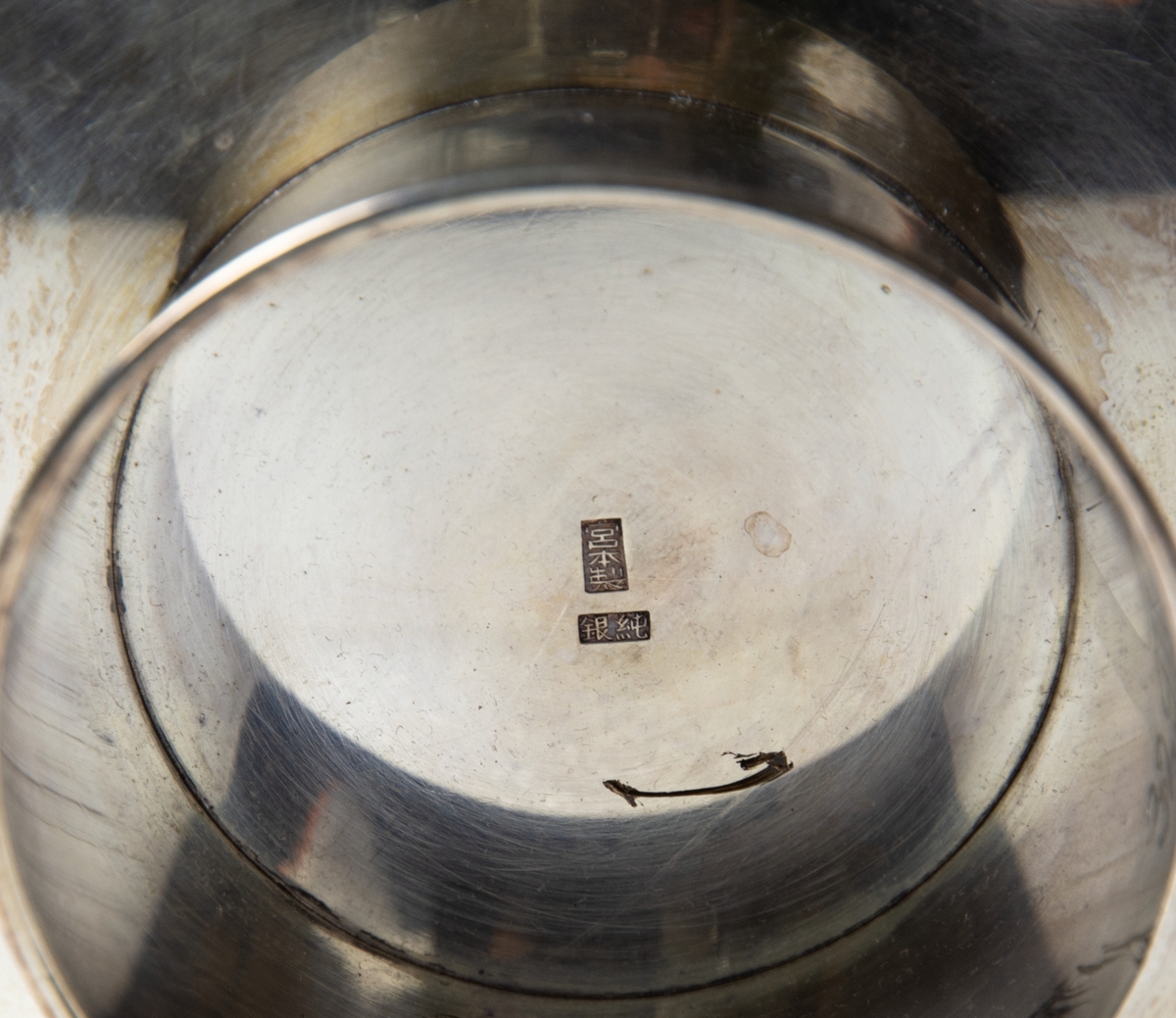 Fat på fot. Fatet har ett ingraverat motiv av flygplanet Douglas World Cruiser med två korsade flaggor framför, japanska och amerikanska. Under planet en karta som visar flygrutten för "Around the World Flight" 1924. Runt fatets insida är japanska skrivtecken ingraverade.