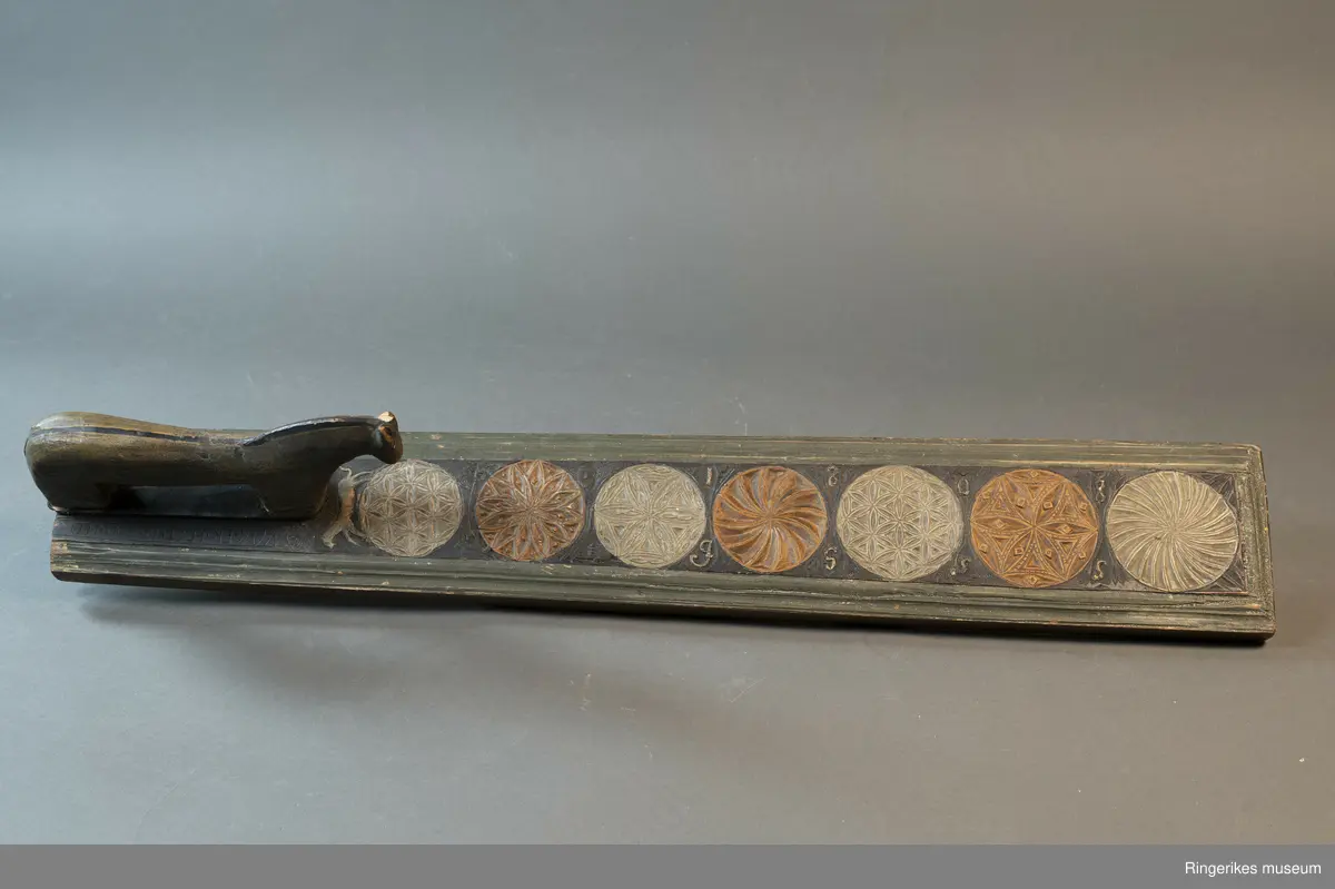 Laget av massivt tre med innfelt hest. Krok av jern i enden, antageligvis sekundær. Rester av lær festet med 3 spiker i enden, antagelig gammelt oppheng. Håndtaket er formet som en hest med man, hvite øyne, ører, og mule. Panneluggen er pent utskåret. Ett øre er ødelagt. Hesten har hale. Man og hale er malt svarte, og det går en svart strek langs ryggen til hesten fra man til hale. Denne er også svart. Halen er kort. Det er en sprekk mellom hesten og mangletreet. Rundt hesten er det innrisset skrift, og to små rosetter i karveskurd, diameter 1.5 cm. Relieff av hund foran hestens forbein. Hunden er malt i grågrønn farge. 

Det er 7 rosetter skåret ut på mangletreet. Hver rosett har sitt spesifikke mønster. Rosett 1,2,3,5,6 har blomstermønster. 4 og 7 har virvler. Annenhver rosett er malt med grågrønn, og annenhver med brun farge. Feltet rundt rosettene er malt svart, med noe utydelig dekor, og tallene 1808 mellom hver rosett fra 3. til 7. På motsatt side er bokstavene JSSS skåret inn. Mangletreet har et grønt felt utenfor det svarte, dette er skåret til en pen profil. Mangletreet bærer i det hele tatt preg av høy kvalitet på håndverket.