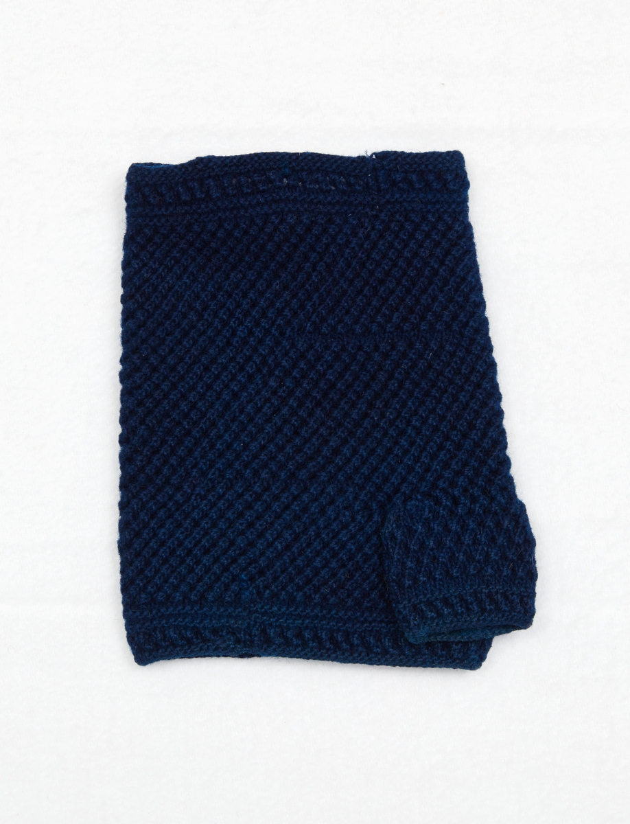 Vante, halvvante, från Nås socken. Stickad av blått ullgarn i aviga och räta maskor som bildar en struktur som liknar kypertränder.