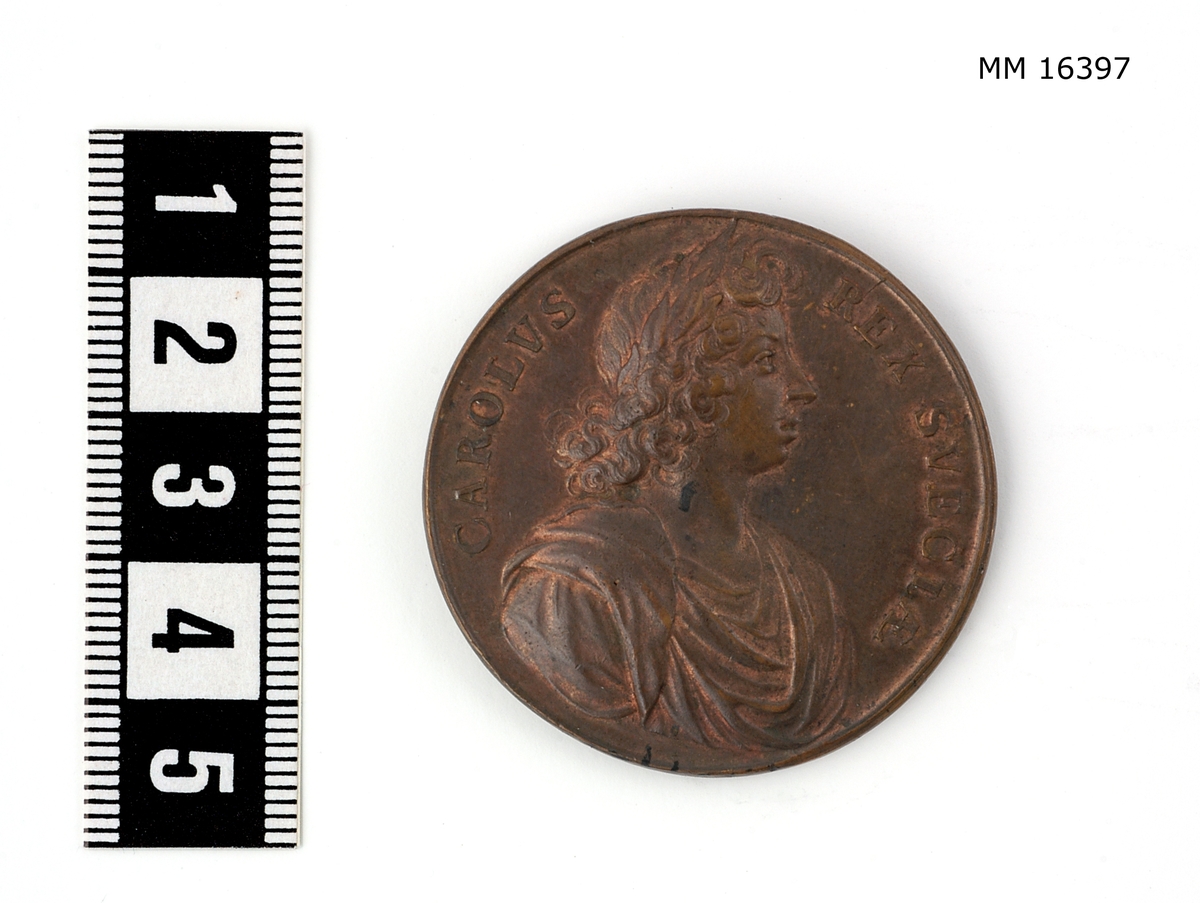 Cylindrisk medalj av brons. Åtsida: CAROLVS REX SVECIAE. Bröstbilden, höger sida, lagerkransad, i mantelveck, halsen bar. Frånsida: NESCIT. OCCASVM. Nordstjärnan klart strålande mellan stora och lilla Björn med flera stjärnbilder på himmelsgloben.