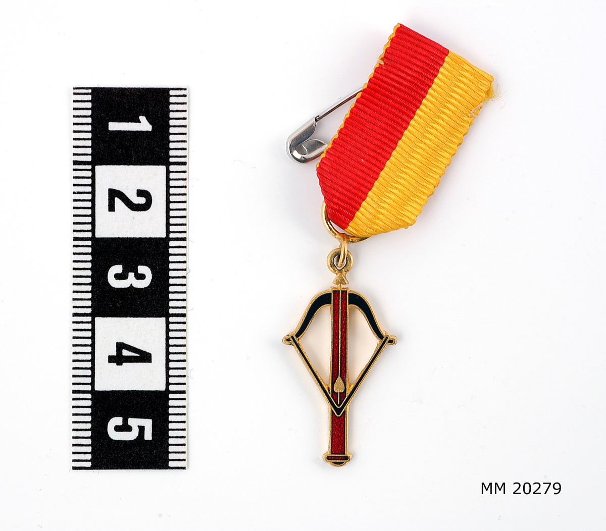 Fartygsorden Småland, 1962. Bestående av armborst, emaljerat i svart och vinrött, fästat i ett ripsband i rött och gult.