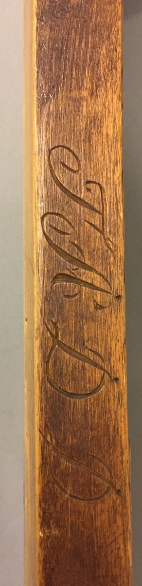 Mangletre med kjevle. Handtak med skoren rosedekor. Handtaket er festa til mangletreet med ein skrue truleg sekundært. Rankedekor i flatskurd. Blomar og c-krullar, Kjevlet er ein rund stokk utan dekor. Det er sett på hemper til oppheng på både mangletreet og kjevlet. På sida av mangletreet er det skore inn bokstavane TÅD(TAD?). Det er òg rissa inn nokre bokstavar, desse er utydlege men den første er truleg ein Ø.