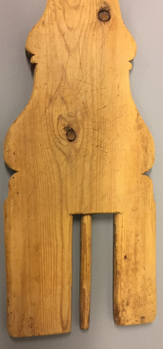 Hoveltre laga av ei fjøl, med eit spor i den eine enden. I dette sporet er der ein smal pinne. Fjøla har handtak i den eine enden.