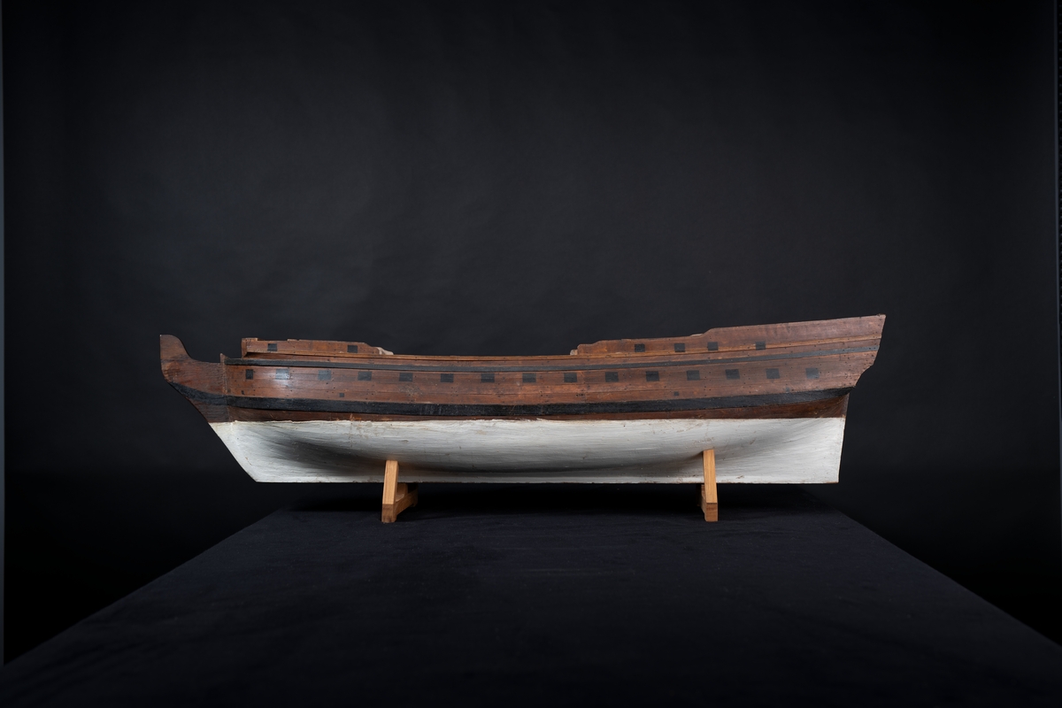 Fartygsmodell 40-kanonfregatt efter 1765 års reglemente. Skrovmodell. Bordläggningen limmad på gavlar, utan inredning, galjon och akterspegel. Modellen brunmålad med svarta kanonportar och under vattenlinjen vitmålad.