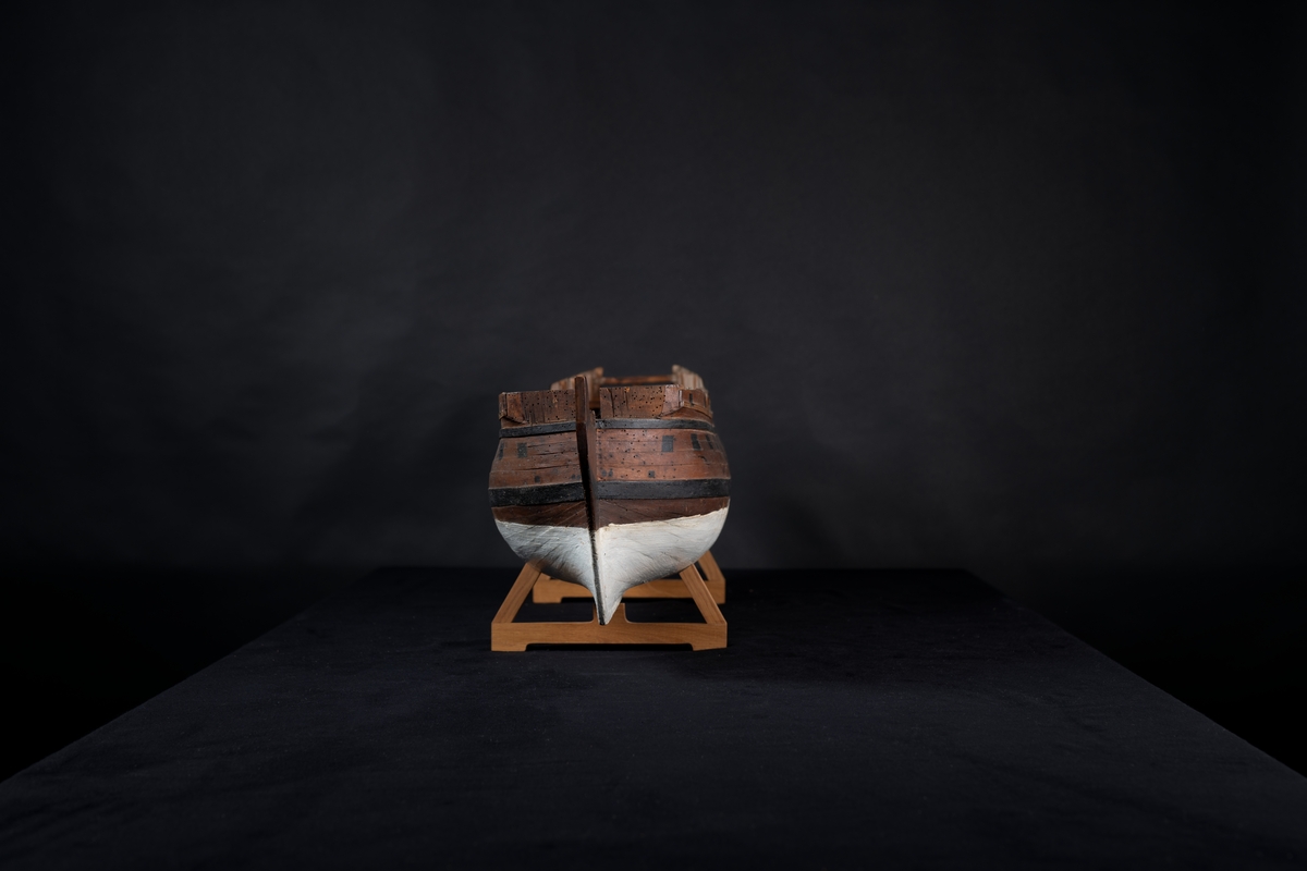 Fartygsmodell 40-kanonfregatt efter 1765 års reglemente. Skrovmodell. Bordläggningen limmad på gavlar, utan inredning, galjon och akterspegel. Modellen brunmålad med svarta kanonportar och under vattenlinjen vitmålad.