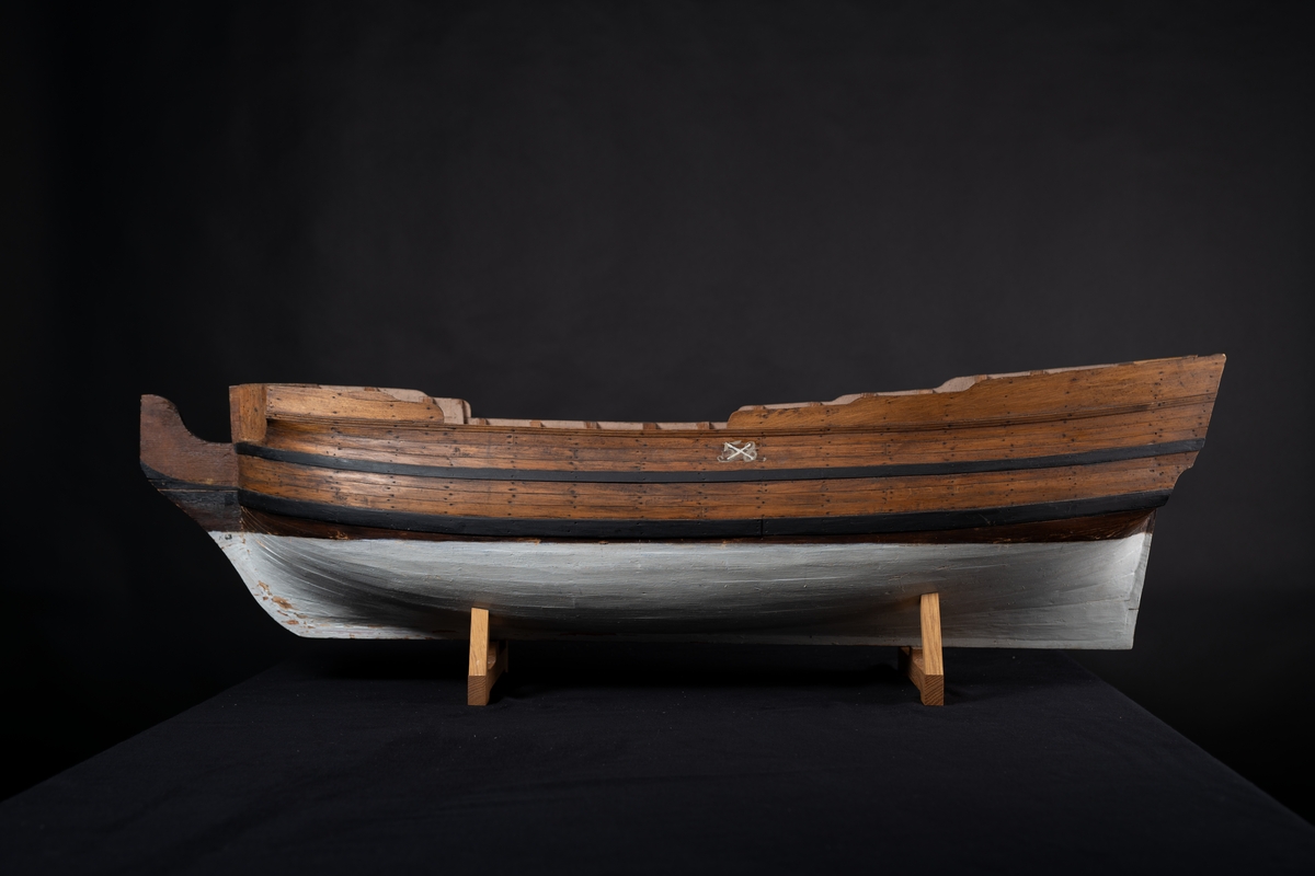 Fartygsmodell 60-kanonsskepp skrovmodell. Bordläggningen limmad på gavlar, utan inredning, galjon och akterspegel. Modellen fernissad och målad med två svarta band, under vattenlinjen vitmålad.