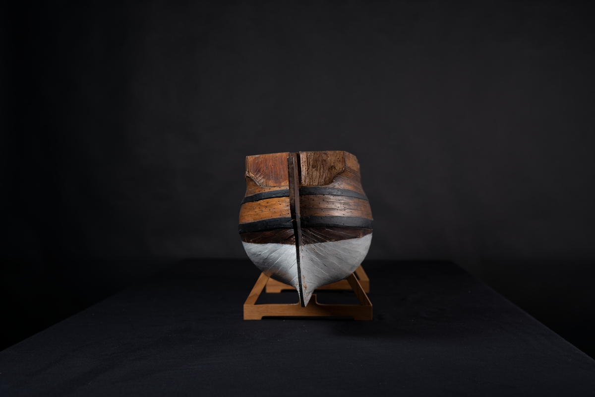 Fartygsmodell 60-kanonsskepp skrovmodell. Bordläggningen limmad på gavlar, utan inredning, galjon och akterspegel. Modellen fernissad och målad med två svarta band, under vattenlinjen vitmålad.