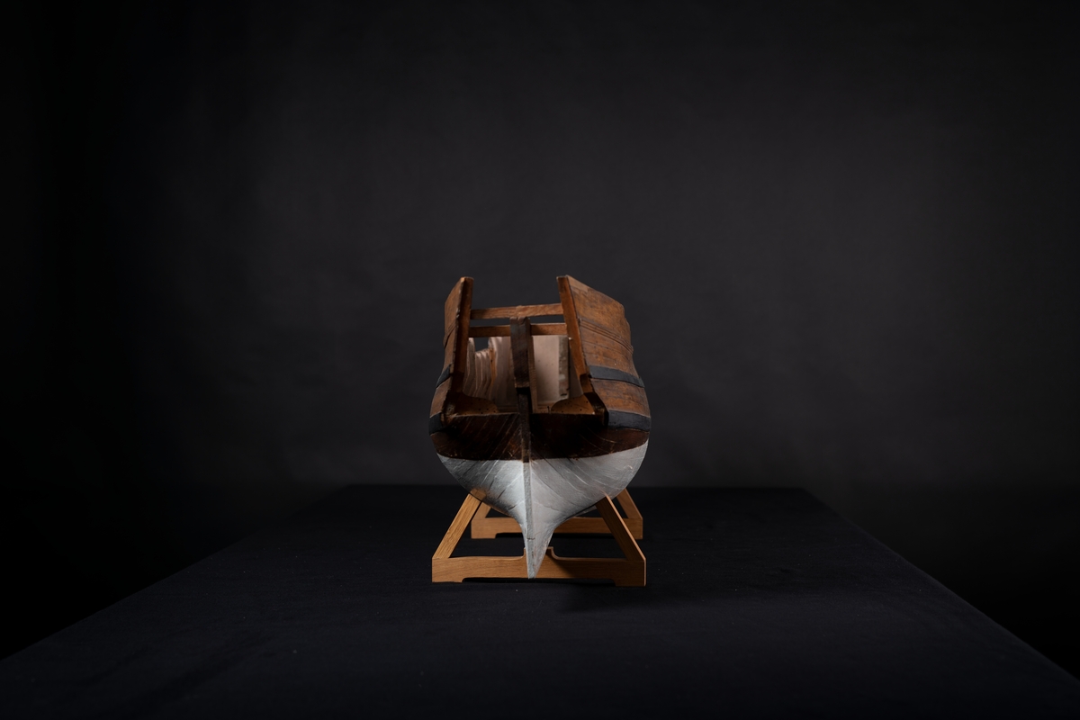 Fartygsmodell 60-kanonsskepp skrovmodell. Bordläggningen limmad på gavlar, utan inredning, galjon och akterspegel. Modellen fernissad och målad med två svarta band, under vattenlinjen vitmålad.