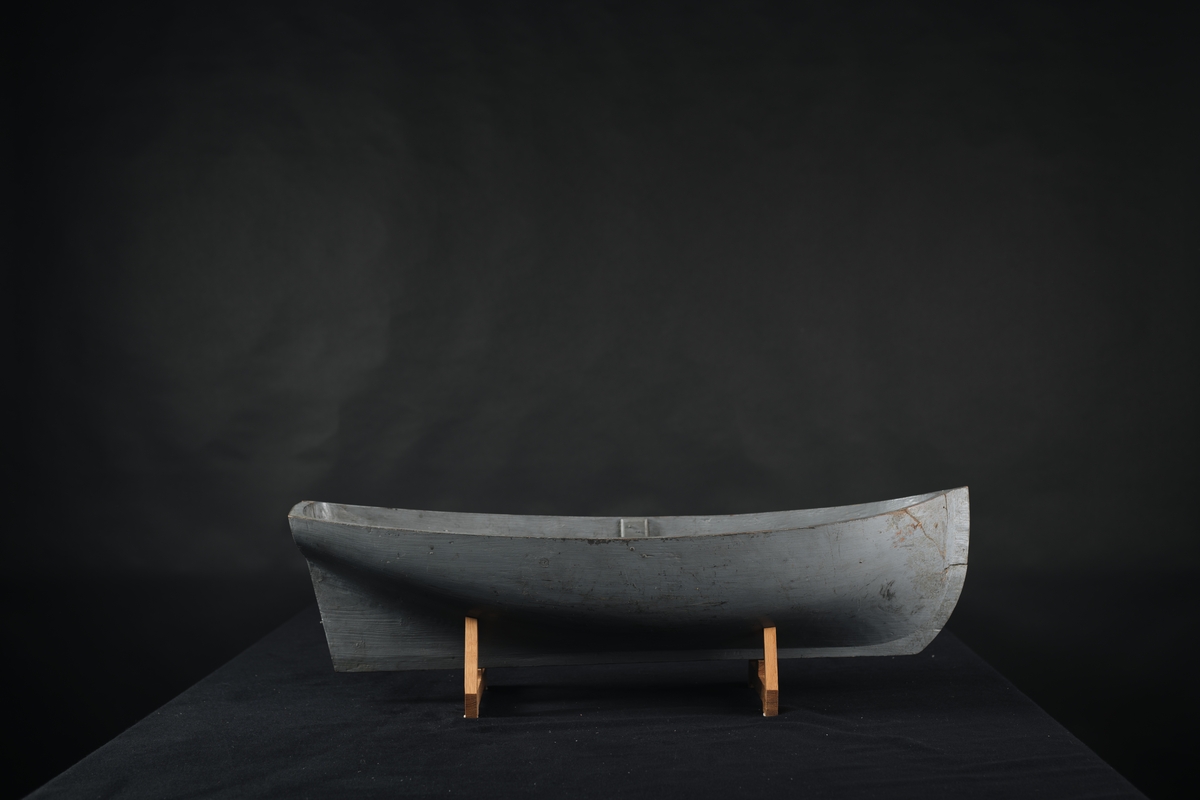 Fartygsmodell, av trä, urholkad ur ett stycke trä, gråmålad.