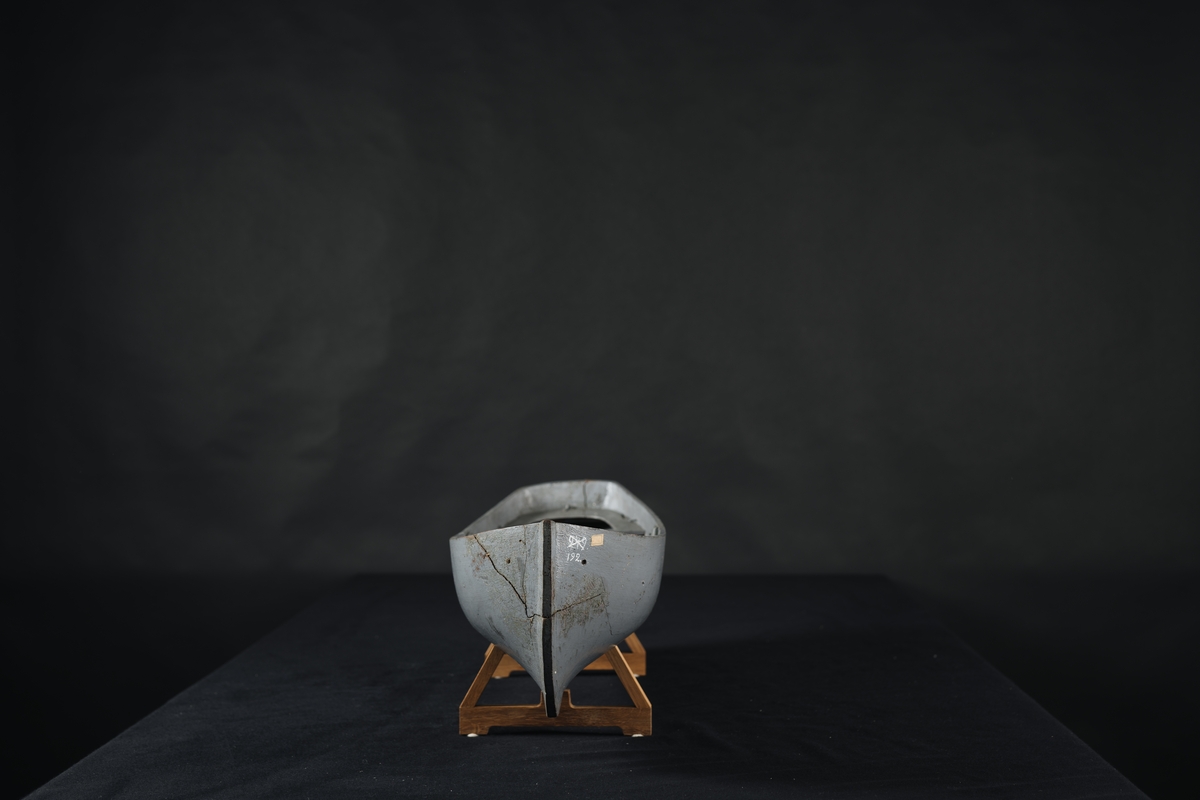 Fartygsmodell, av trä, urholkad ur ett stycke trä, gråmålad.