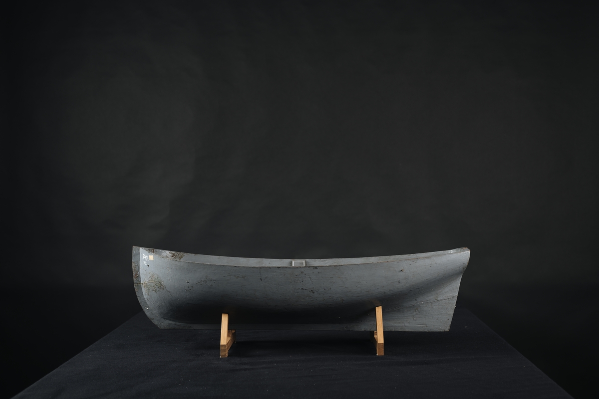 Fartygsmodell, av trä, urholkad ur ett stycke trä, gråmålad.