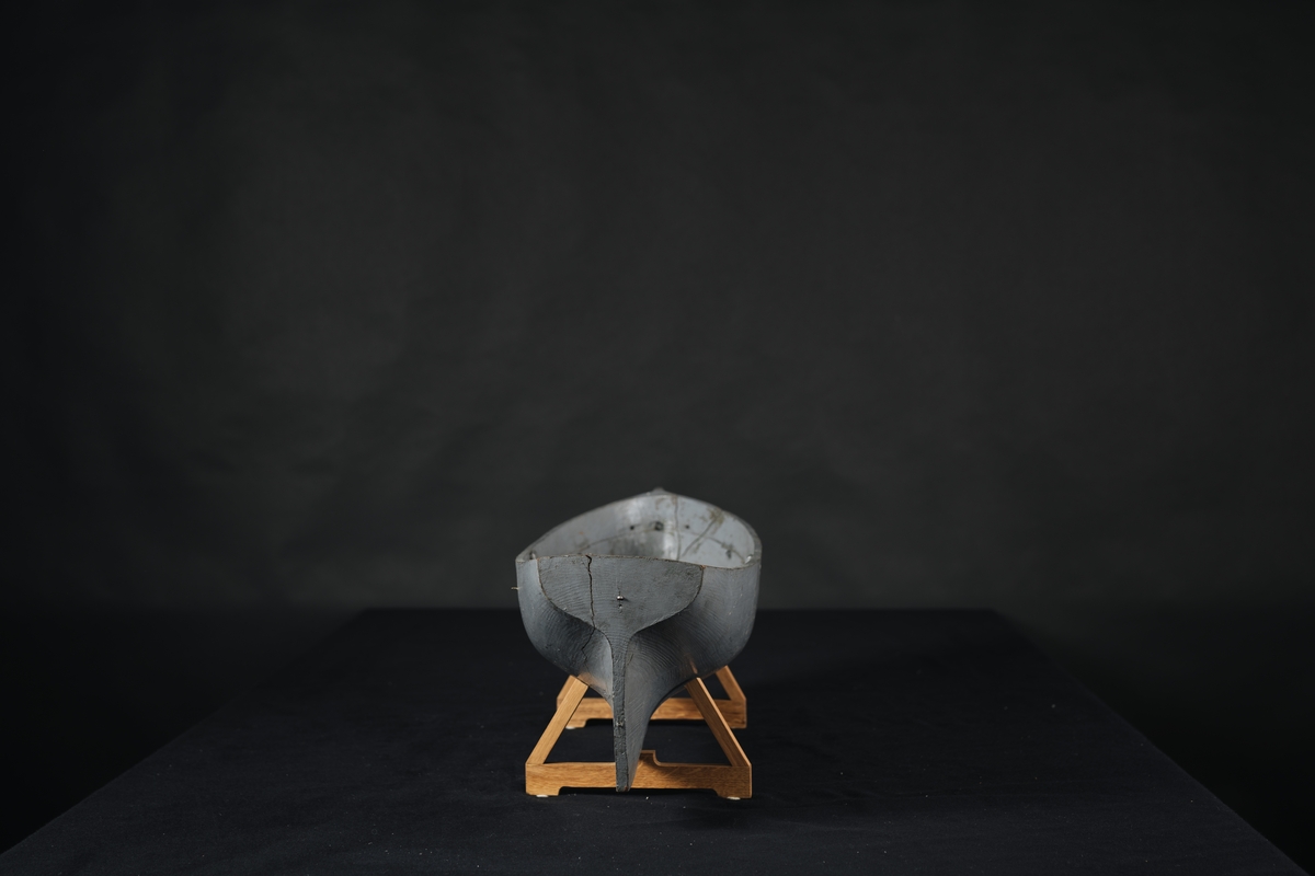 Fartygsmodell, av trä, urholkad ur ett stycke trä, gråmålad.