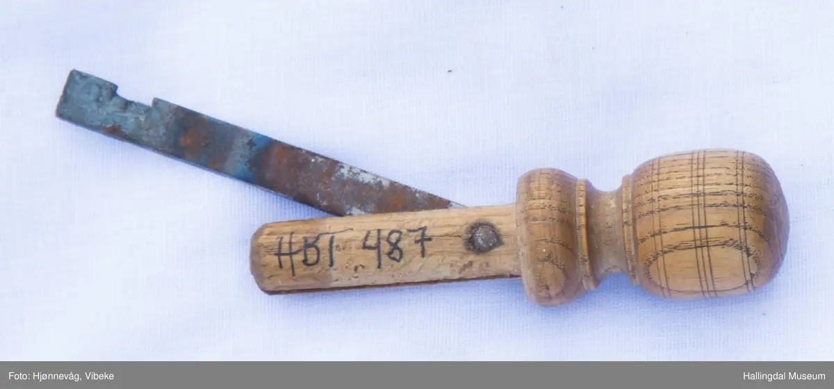 Metall som er festet på et dreid håndtak.  Kan regulere vinkelen fra håndtaket fordi metallet er festet med en bolt gjennom håndtak og jern i den ene enden.