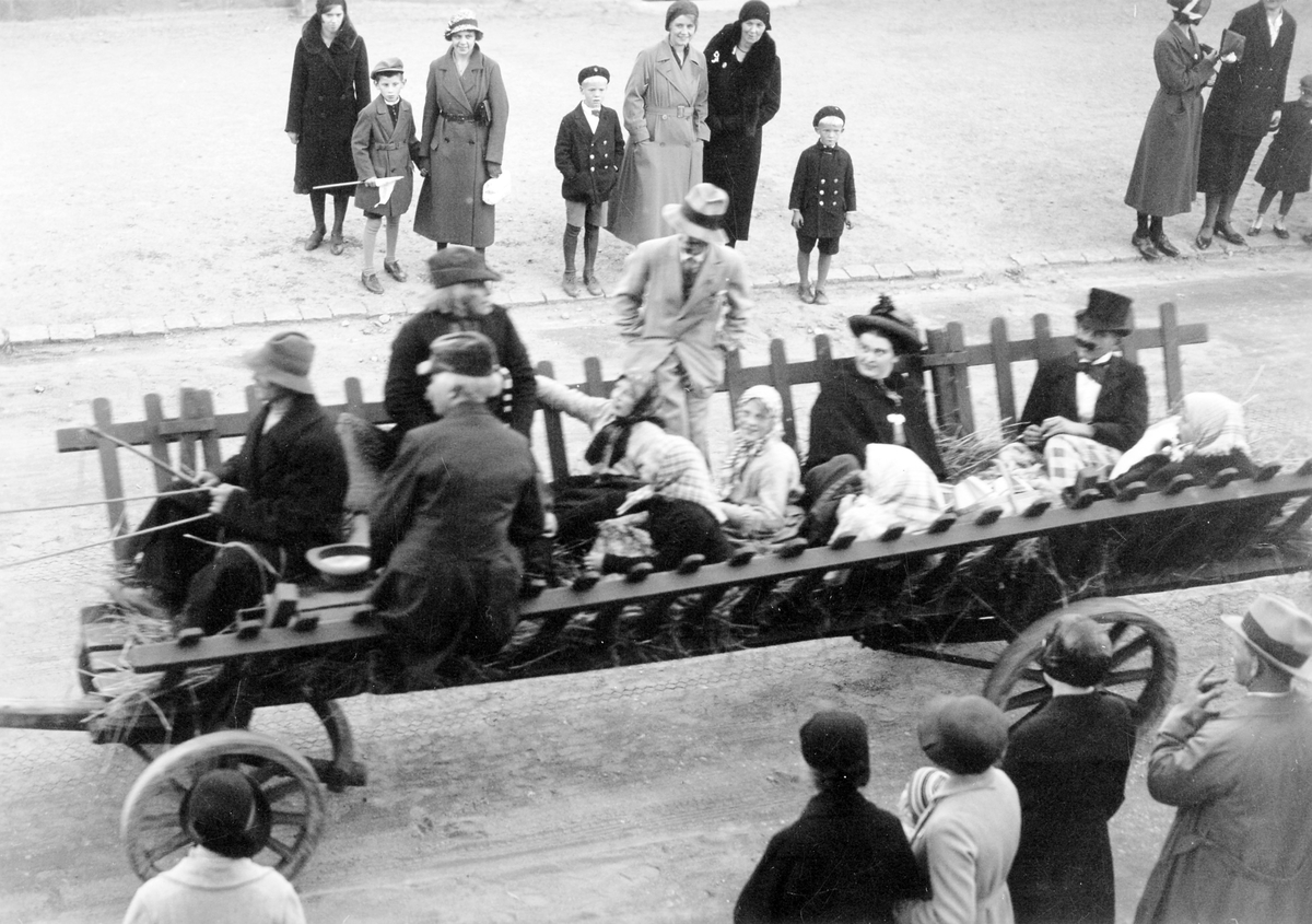 Barnens dag 1938. Hästvagn med barn, kvinnor och män kör förbi en folksamling.
