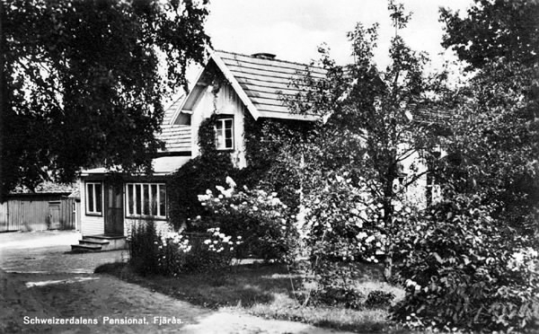 Vykort, "Schweizerdalens Pensionat, Fjärås." Exteriörbild av pensionatet med trädgård, som ligger vid sjön Lygnern. Till vänster syns i bakgrunden ett uthus.