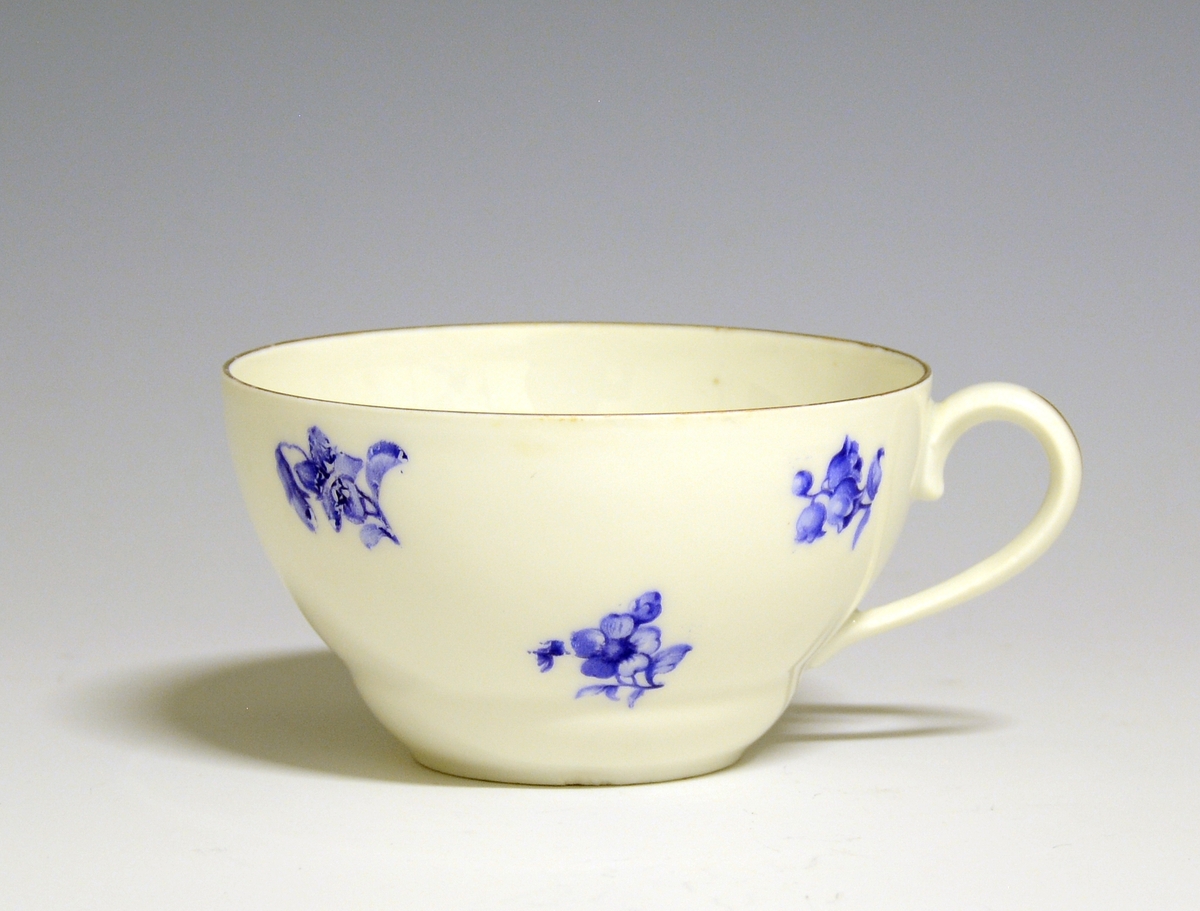 Kaffekopp med skål av porselen. Hvit glasur. Dekorert med spredte, blå blomster,
Modell: 377 (usikker)

Fabrikkmerke: Grønt anker med PP (1911-1935).
Finnes i priskuranten for 1931.