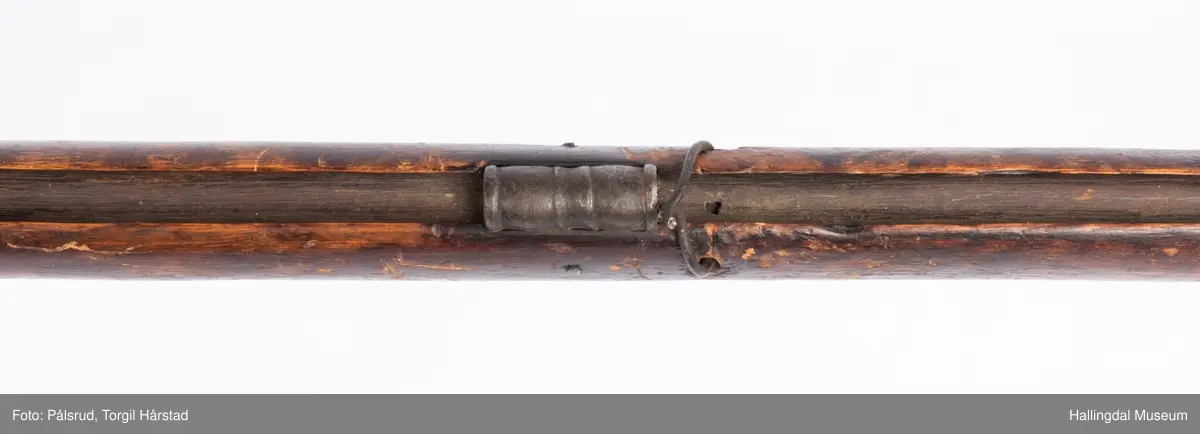 Gevær med perkusjonslås og kassepipe. Har mest sannsynlig vært ombygd fra flintlås. Geværet har kassepipe - har firkantet løp bakerst fra låsen til siktet midt på løpet. Fra låsen til siktet midt på løpet er løpet kasseformet og har en dekorert overgang til et svakt avrundet åttekantet løp. Det fremste siktet er av messing. Kolbekappen er festet med to skruer. Mangler avtrekksbøyle, reim og ladestokk. Montert på patentsvansskrue ved ombygging. Løpet er 15 cm i diameter og glattløpet.