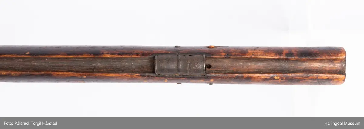 Gevær med perkusjonslås og kassepipe. Har mest sannsynlig vært ombygd fra flintlås. Geværet har kassepipe - har firkantet løp bakerst fra låsen til siktet midt på løpet. Fra låsen til siktet midt på løpet er løpet kasseformet og har en dekorert overgang til et svakt avrundet åttekantet løp. Det fremste siktet er av messing. Kolbekappen er festet med to skruer. Mangler avtrekksbøyle, reim og ladestokk. Montert på patentsvansskrue ved ombygging. Løpet er 15 cm i diameter og glattløpet.