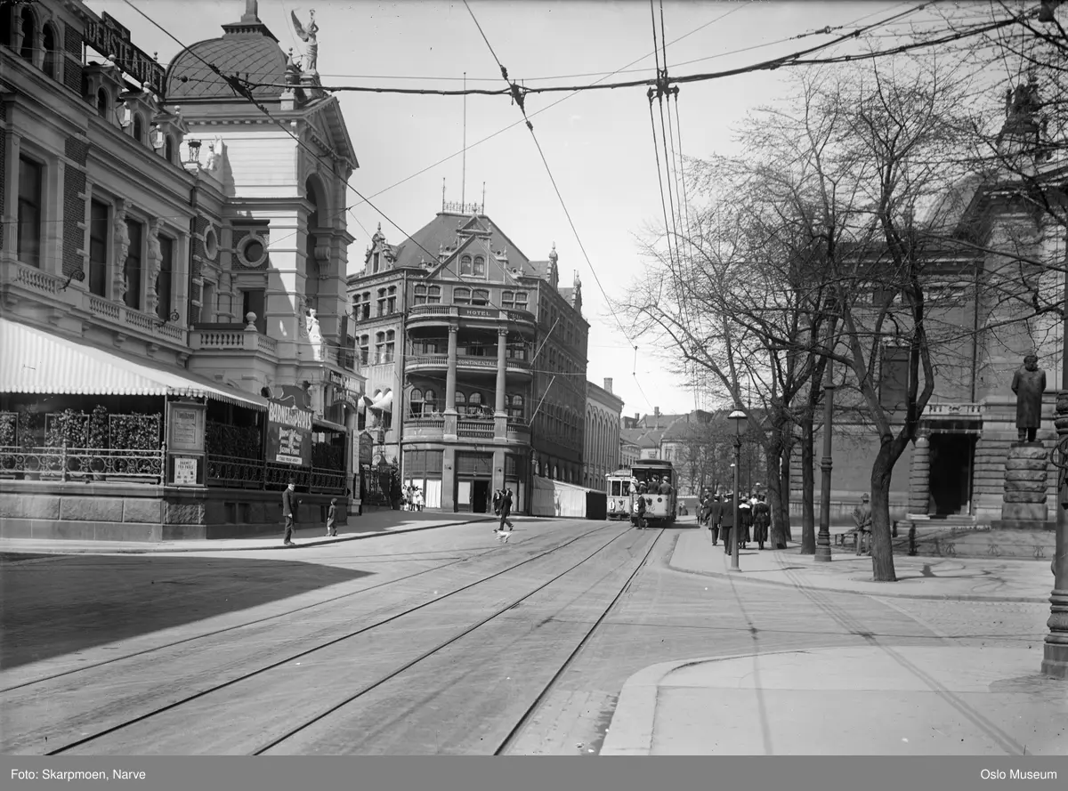 gateløp, trikkeskinner, trikker, mennesker, Tivolis hovedbygning, Hotel Continental, Nationaltheatret, portrettstatue