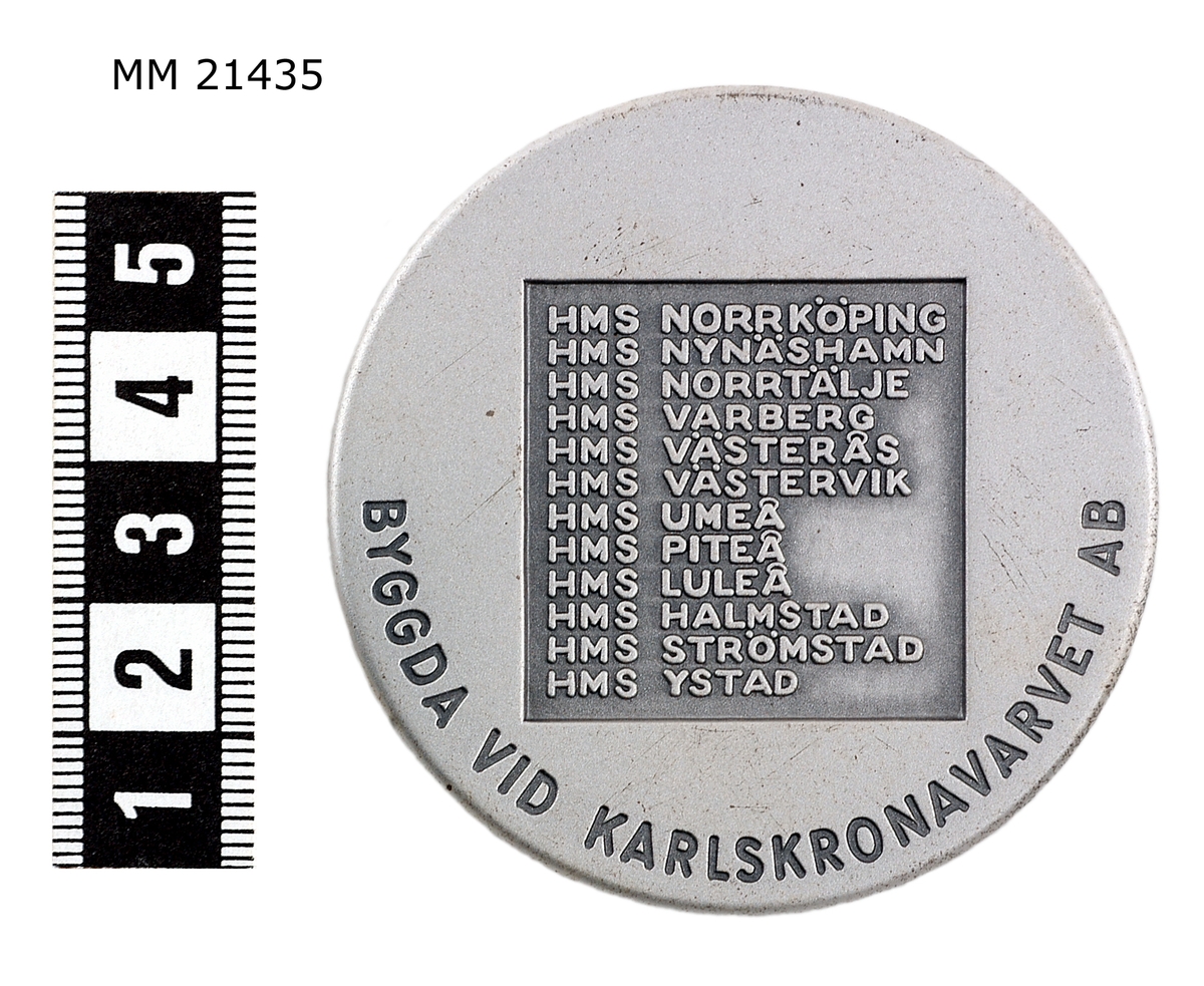 Minnespenning  av vitmetall, kraftig med djup dekor, utan kant. Åtsida: Spica på sjön med fören mot bildytan. Markerade moln. Överst text: "SPICA 1973-76". Frånsida: ruta med infälld text: samtliga robotbåtar av Norrköpingklass samt längs kanten: "BYGGDA VID KARLSKRONAVARVET AB"

På kanten "SPORRONG".