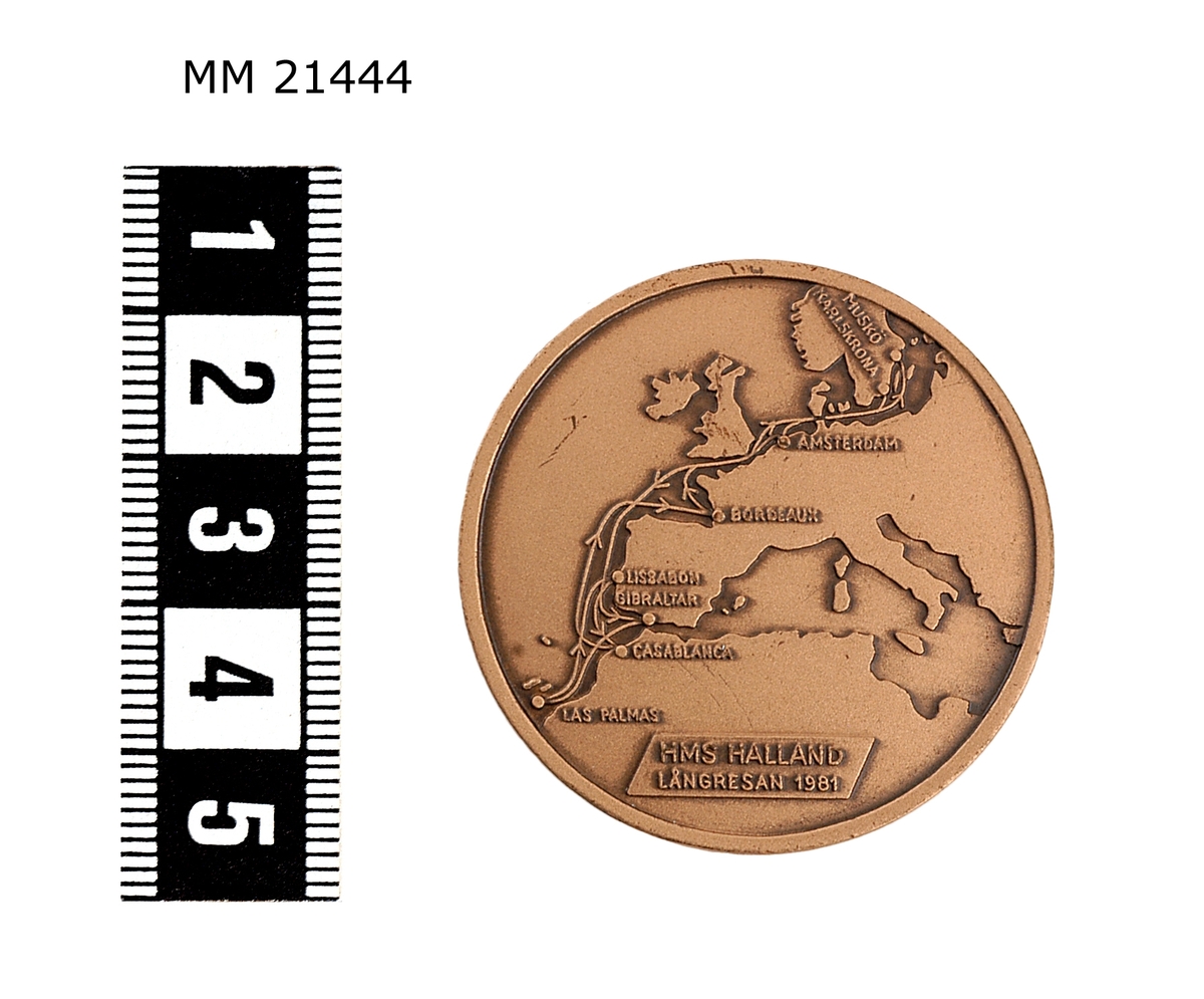 Minnespenning av brons. Åtsida: Fartyg på sjön visande babordssidan. Nedanför krönt stockankare. Ovanför text: "HMS HALLAND". Frånsida: Europa- Afrikakarta med hamnarnas namn. Banderoll med text: "HMS HALLAND LÅNGRESAN 1981".