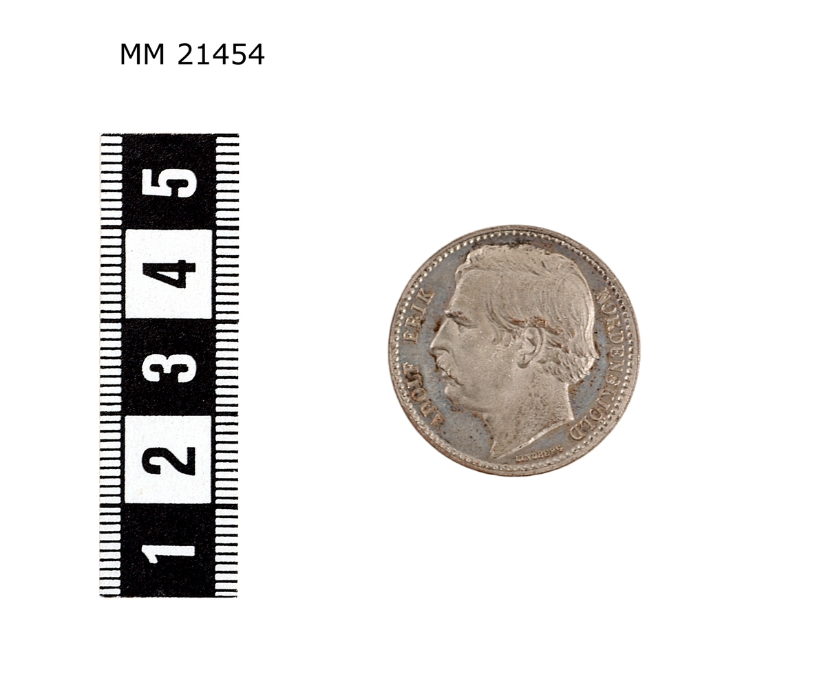 Minnespenning av silverplätering. Åtsida: Huvud i profil av man med mustasch. Under bild text : "LINDBERG". Längs kanten text: "ADOLF ERIK NORDENSKIÖLD". Prickad rand längs kanten.

Frånsida Lagerkrans runt kanten, överst strålande stjärna, text i mitten: "NORDOSTPASSAGEN FULLBORDAD 1878-79".