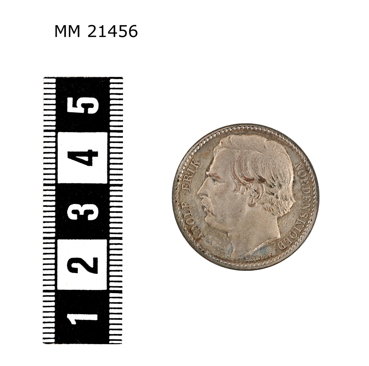 Minnespenning av silverplätering. Åtsida: Huvud i profil av man med mustasch. Under bild text : "LINDBERG". Längs kanten text: "ADOLF ERIK NORDENSKIÖLD". Prickad rand längs kanten.

Frånsida Lagerkrans runt kanten, överst strålande stjärna, text i mitten: "NORDOSTPASSAGEN FULLBORDAD 1878-79".