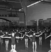 Gymnastikuppvisning i idrotthuset i Huskvarna år 1957. Ledaren är gymnastikdirektör Karin