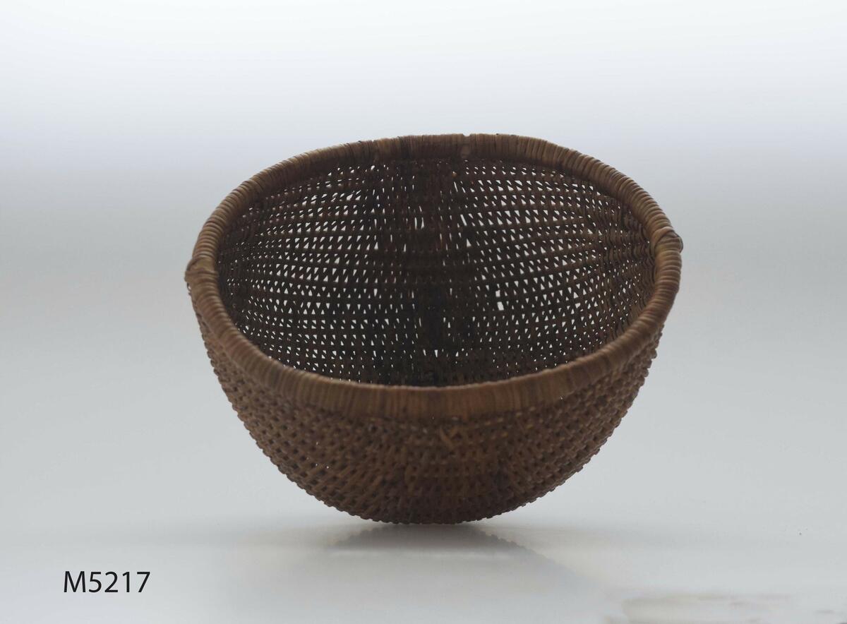 Korg, flätad av tågor. Oval. Bukig. På fot. Med lock. Locket har haft handtag. Västermarks by, Attmars socken, Medelpad.