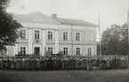 Militärövning på Huseby, 1917.
Genomgång av övningen, utanför huvudbyggnaden på Huseby. Militärerna är iförda blandade modeller av
militäruniform, några dock i m/10.