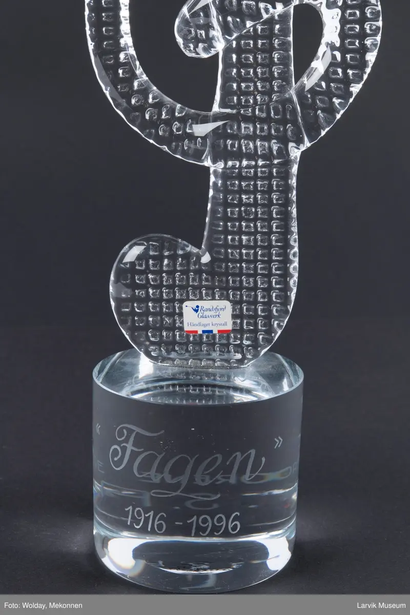 Glass skulptur formet som en G-nøkkel.
