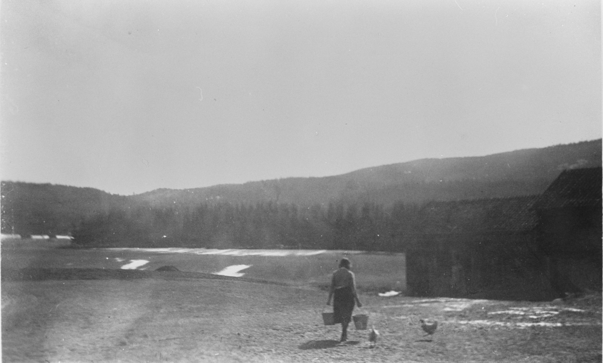 Åse Langerud på vei med fôr til hønsene. Langerud, 1950-årene.