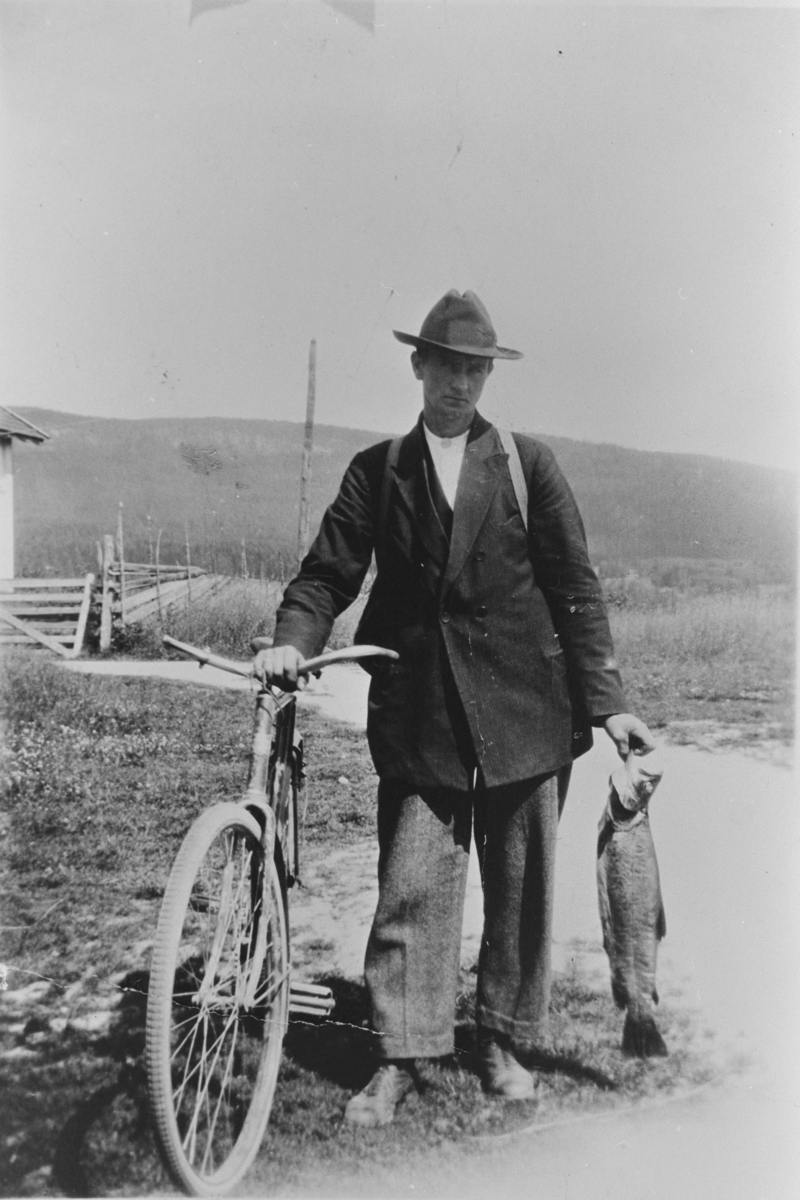 Torstein Velstad med sykkel, etter fisketur til Eggedal ca. 1920. Fisken veide nesten 5 kg. 