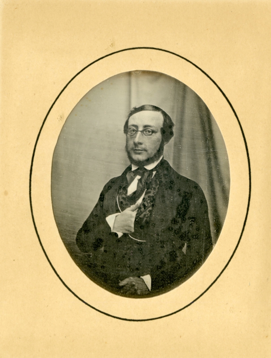 Christian H.H.Rømer med briller, glatt hår, silketørkle, klokkekjede, høyre hånd innenfor jakke