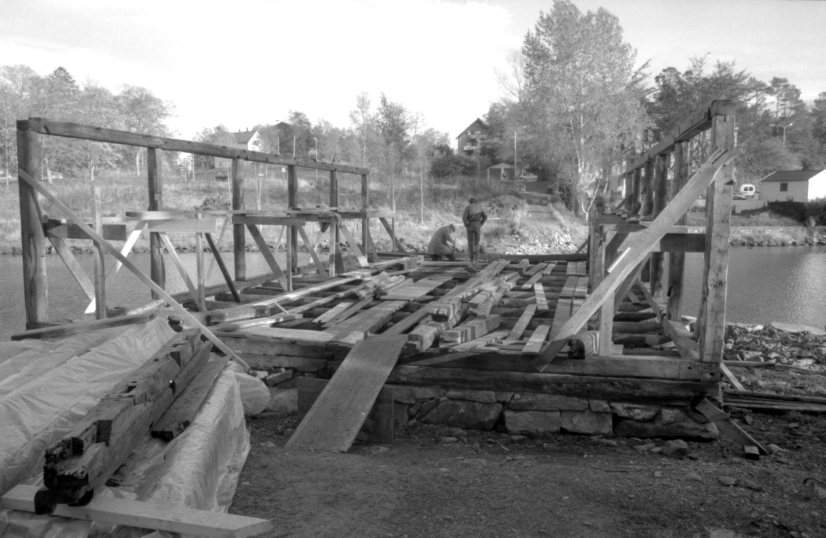 Dokumentasjonsbilder i serie fra gjenoppføringa av Larsnesbua, også kallt Seljeset-buda på Sunnmøre Museum, februar 1992. Einar Fagerli er arbeidsleiar for arbeidet, og det er gjennom "Arbeid for trygd"- ordninga ein har fått folk til arbeidet.