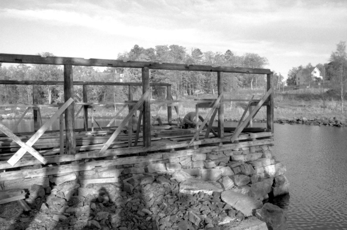 Dokumentasjonsbilder i serie fra gjenoppføringa av Larsnesbua, også kallt Seljeset-buda på Sunnmøre Museum, februar 1992. Einar Fagerli er arbeidsleiar for arbeidet, og det er gjennom "Arbeid for trygd"- ordninga ein har fått folk til arbeidet.