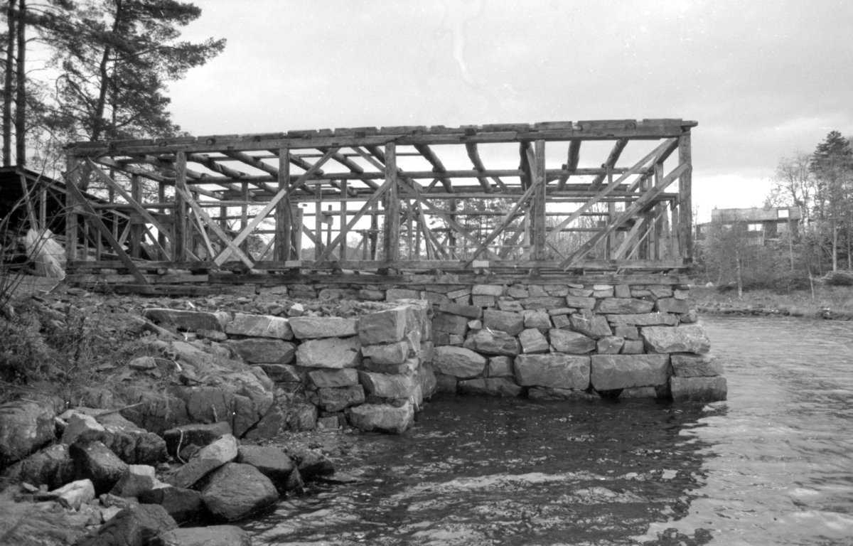 Dokumentasjonsbilder i serie fra gjenoppføringa av Larsnesbua, også kallt Seljeset-buda på Sunnmøre Museum, februar 1992. Einar Fagerli er arbeidsleiar for arbeidet, og det er gjennom "Arbeid for trygd"- ordninga ein har fått folk til arbeidet.