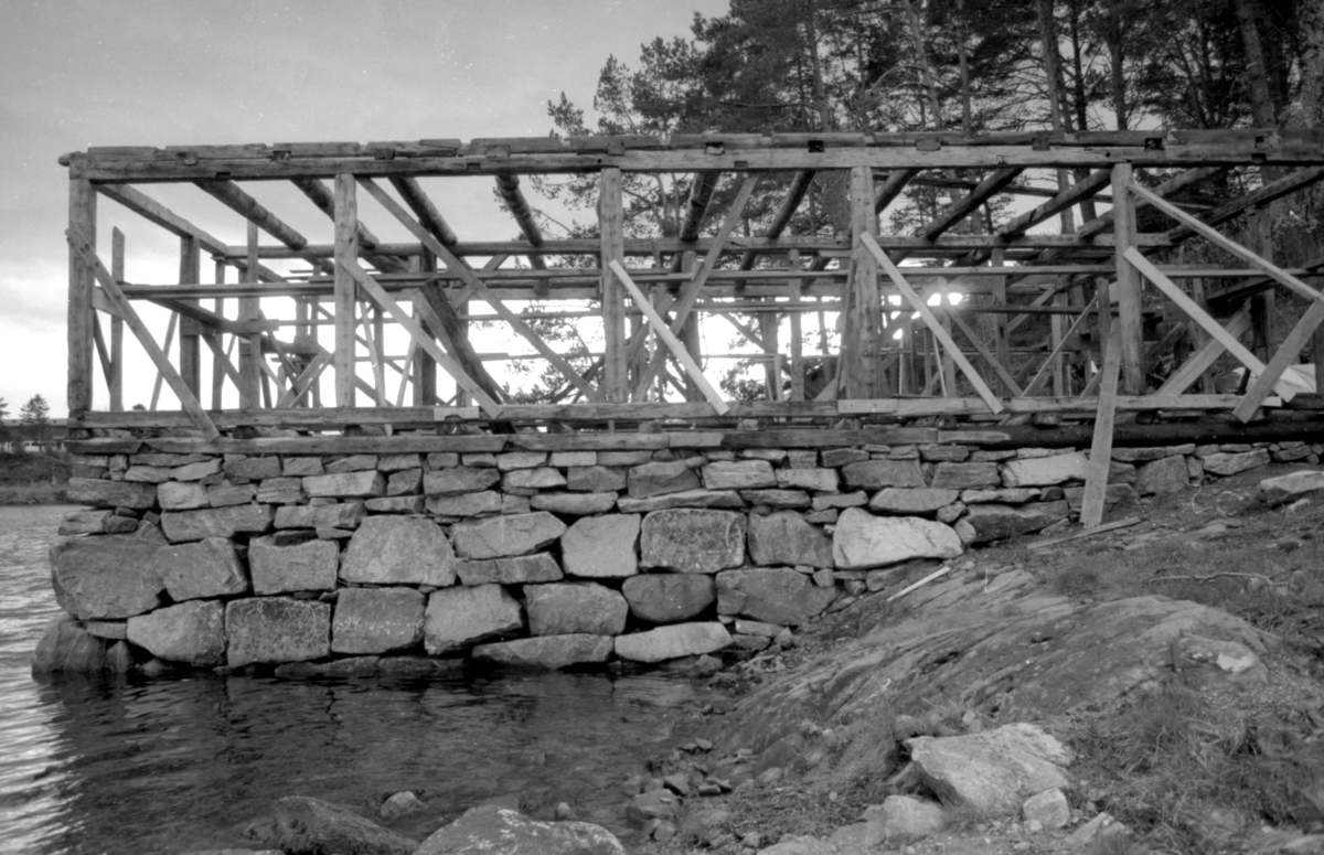 Dokumentasjonsbilder i serie fra gjenoppføringa av Larsnesbua, også kallt Seljeset-buda på Sunnmøre Museum, februar 1992. Einar Fagerli er arbeidsleiar for arbeidet, og det er gjennom "Arbeid for trygd"- ordninga ein har fått folk til arbeidet.