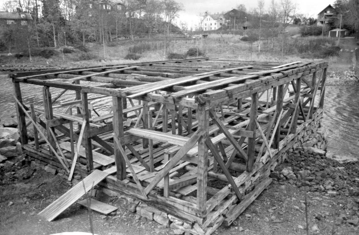 Dokumentasjonsbilder i serie fra gjenoppføringa av Larsnesbua, også kallt Seljeset-buda på Sunnmøre Museum, februar 1992. Einar Fagerli er arbeidsleiar for arbeidet, og det er gjennom "Arbeid for trygd"- ordninga ein har fått folk til arbeidet.