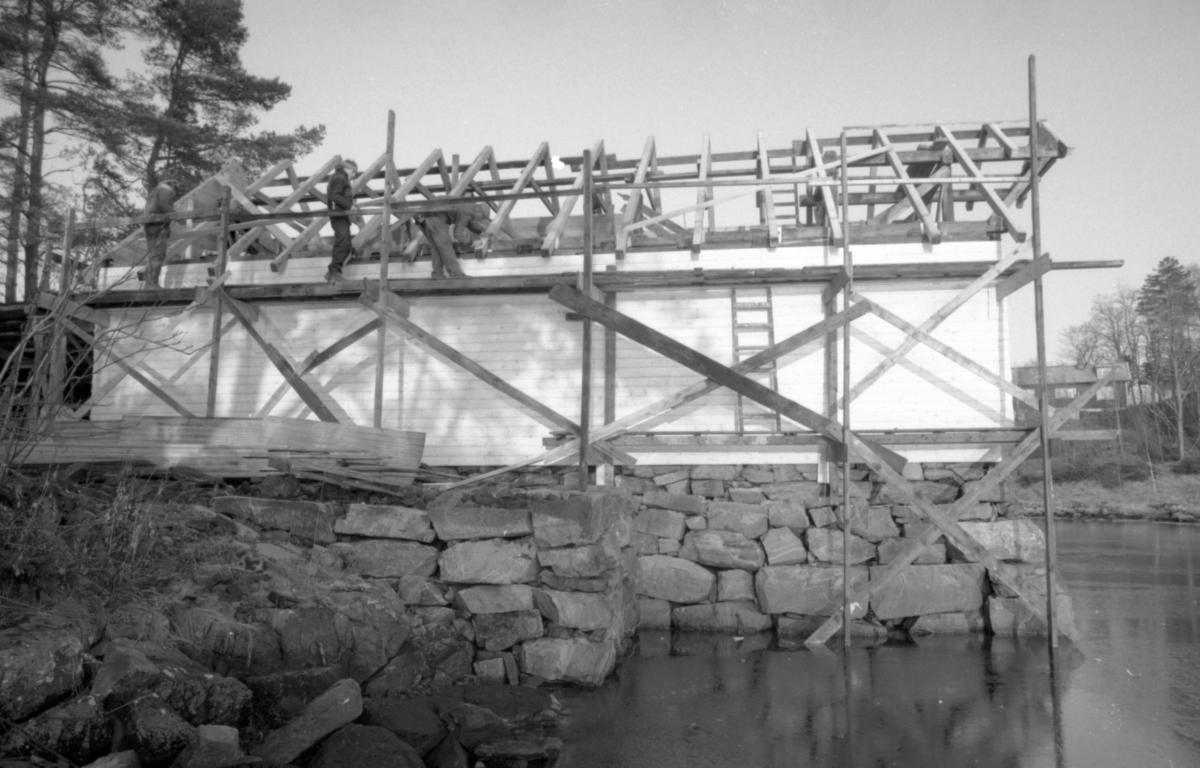 Dokumentasjonsbilder i serie fra gjenoppføringa av Larsnesbua, også kallt Seljeset-buda på Sunnmøre Museum, februar 1992. Einar Fagerli er arbeidsleiar for arbeidet, og det er gjennom "Arbeid for trygd"- ordninga ein har fått folk til arbeidet.