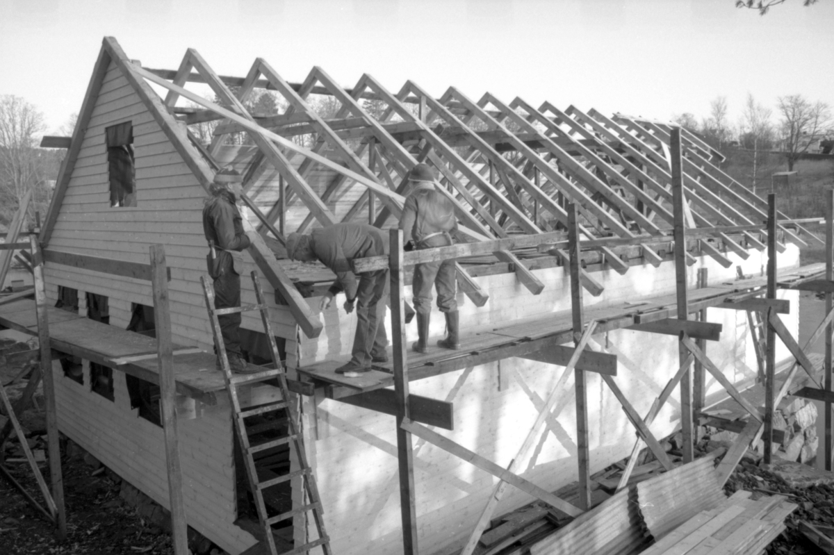Dokumentasjonsbilder i serie fra gjenoppføringa av Larsnesbua, også kallt Seljeset-buda på Sunnmøre Museum, februar 1992. Einar Fagerli er arbeidsleiar for arbeidet, og det er gjennom "Arbeid for trygd"- ordninga ein har fått folk til arbeidet.