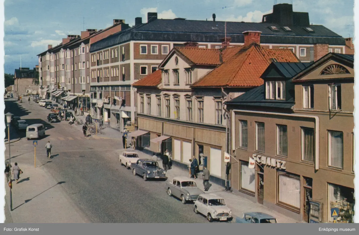 Kungsgatan vid Stora torget, Enköping, tidigt 1960-tal.

Husen närmast i bild revs när PAUS-huset byggdes. PAUS-huset stod färdigt 1971.