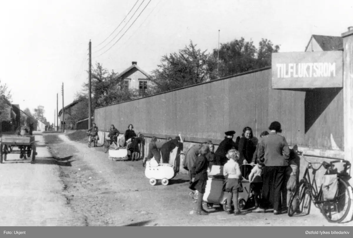 Noen kikker gjennom plankegjerdet for å se på de arresterte i Sarpsborg  i fredsdagene i mai 1945.