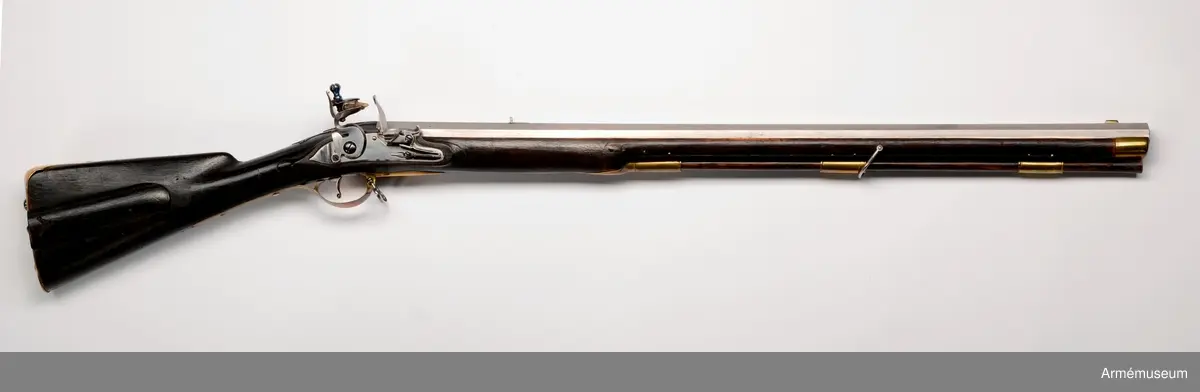 Pipan är åttkantig. Längst bak är tjockleken 3,4 cm, över mellanrörkan är den 2,8 cm och vid mynningen är den 3,1 cm ("stukat gods"). Loppet har åtta halvrunda spiralräfflor, som gör 3/4 varv på piplängden. Ett med fot försett järnsikte sitter inlaxat i pipans omkr 14 cm framför bakänden. Ett mässingskorn, som har laxfot sitter 2,9 cm bakom mynningen. På pipans översida krönt N T (Norrtälje). På undersidan ett R och ett P. Pipan har häften och fasthålles med stift. 

Låset har platt, med bräckta kanter och försänkt bakspets försett bleck. Pannskruven går inifrån men skruven för eldstålsfjädern går utifrån. Hanen har varhake och fängpannan har både eldskärm och arm, som stöder eldstålsskruven. På bleckets utsida under eldstålsfjädern stämpel med C B.

Stocken är av björk och svart. Framstocken är falsad längs laddstocksrännans kanter och vid svansskruvsstjärtens slut finns ett enkelt bladornament. På kolvens högra sida en med skjutlock försedd kolvlåda. På samma sida är nummret 149 inslaget, men på vänstra sidan står siffran 2. 

Alla beslag är av mässing. Sidblecket är stort, platt med bräckta kanter, nära nog trekantigt, dock med de två översidorna fasonerade. Bakplåten har spets, som går in över kolvryggen och som där är fäst med en skruv. I själva bakplåten sitter två skruvar, som ha utstående huvud. Varbygeln är rätt låg. Dess främre arm har docka, den bakre fasthålles av två skruvar. De tre släta, rätt långa rörkorna är litet kullriga samt ha förstärkt bak- och framkant. Näsblecket fasthåles av ett stift. Den främre rembygelns skruv går genom framstocken litet framför mellanrörkan, men den nedre rembygelns går genom varbygelns främre del.Laddstocken är av trä. Tjockänden är skodd med horn. På smaländen sitter ett rätt långt järnbeslag, som har ett gängat hål för kratsen. I kolvlådan förvaras en krats.