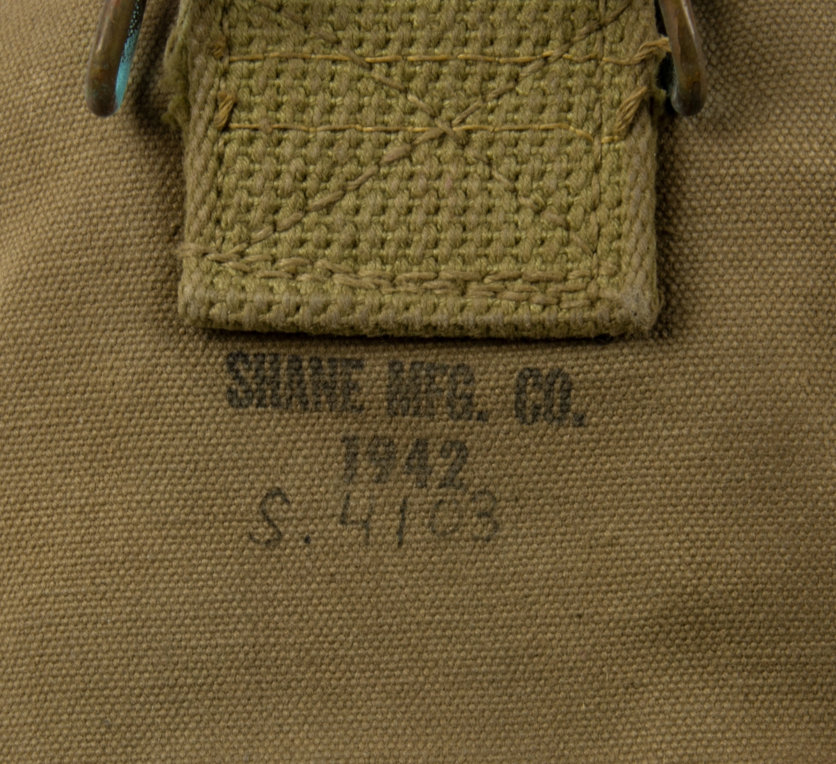 Fältflaska och mätkärl i kanvasfodral. På fodralets framsida står "U.S. stämplat och på baksidan "SHANE MFG. CO 1942" samt påskriften "S.4103".
Inuti fodralet förvaras en fältflaska och ett koktjärl instoppat i varandra.
I botten på fältflaskan står det: "U.S. VOLLRATH 1943" präglat och på handtaget till matkärlet står det "US FOLEY MFG CO 1944".