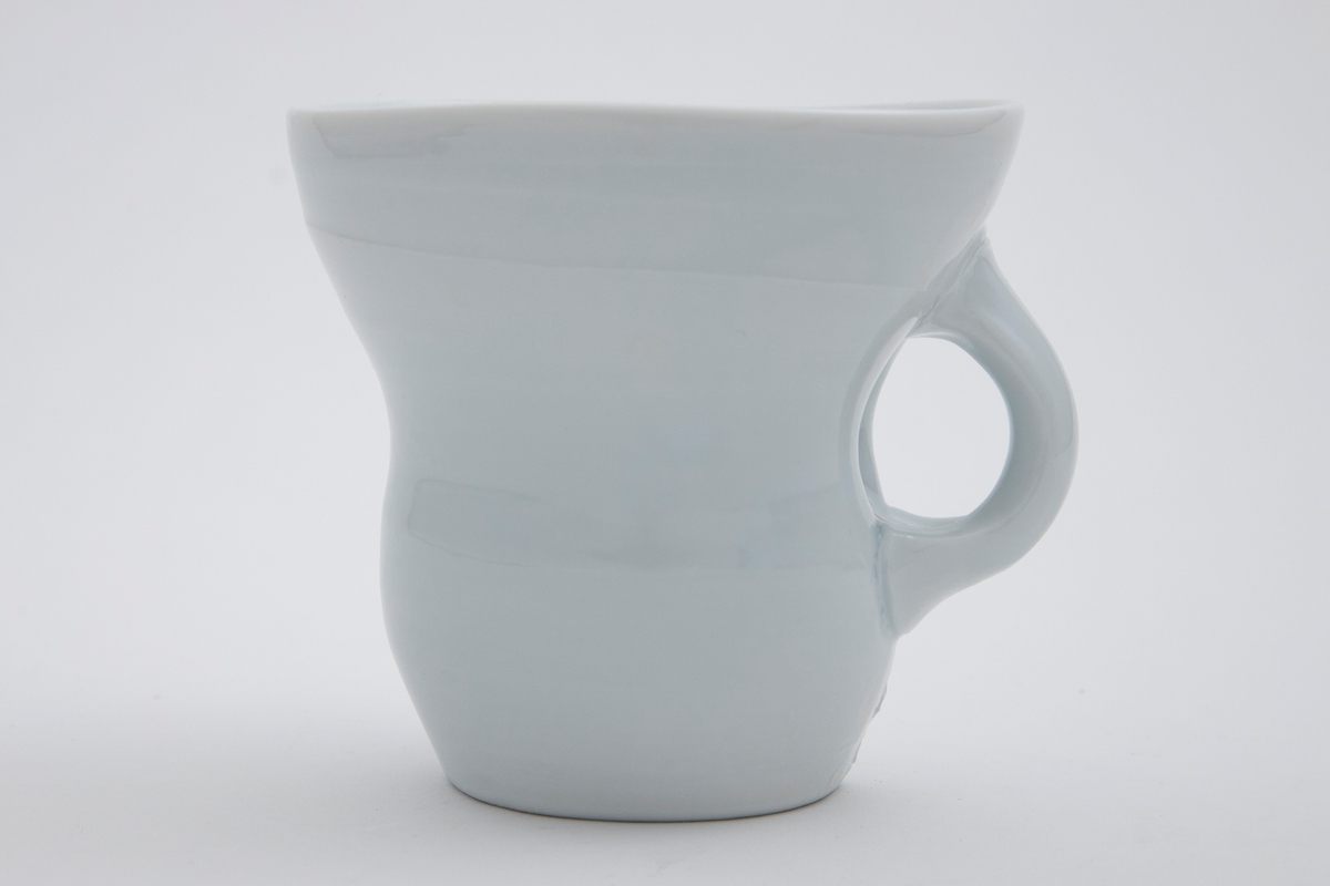 Stor hvit kopp med et hint av lys blå celadon på utsiden og mer synlig celadon på innsiden.