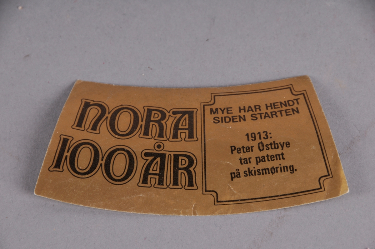 Merkelapp, truleg til brusflaske. Med tekst.