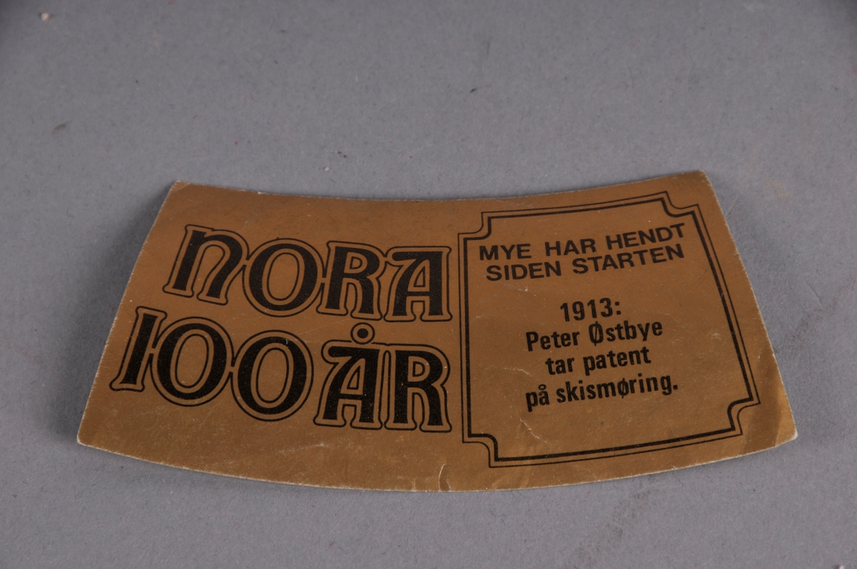 Merkelapp, truleg til brusflaske. Med tekst.