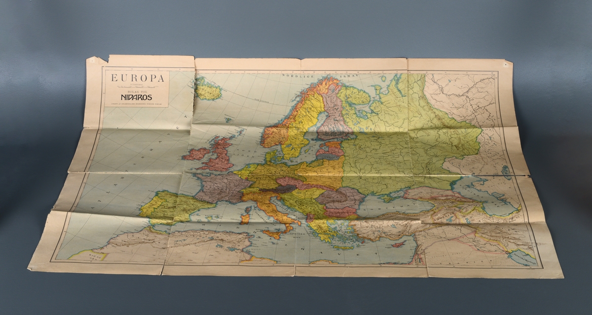 Et europkart som trolig er fra mellomkrigstiden. Det er sammenleggbart og trykt på papir. Øverst til venstre er det en informasjonsboks, se "Påført tekst/merker". Kartet viser Europa inkludert Russland, det nordlige Afrika og det vestlige av det gamle Østen. Landene har ulike farger og grensene er markert. Hovedstede, større byer, elver, sjøer, fjell osv er markert (også med tekst. Lengde- og breddegrader er også markert.